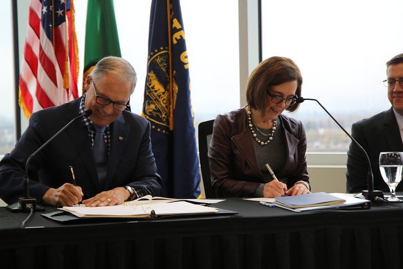 Governors Inslee and Brown sign the joint memorandum of intent.